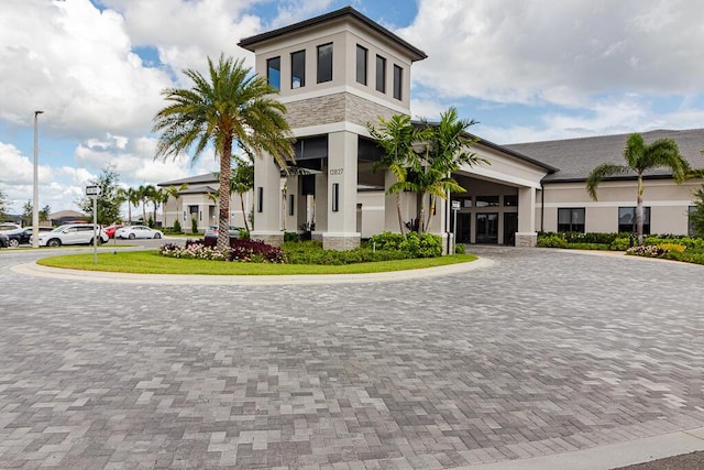 13509 SW Oceanus Blvd, Port Saint Lucie, FL 34987 - view of front facade with stucco siding, curved driveway, and stone siding