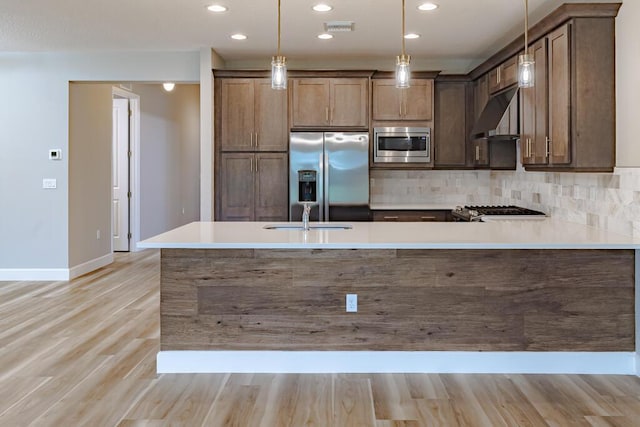 13509 SW Oceanus Blvd, Port Saint Lucie, FL 34987 - kitchen with stainless steel appliances, a sink, hanging light fixtures, light wood-style flooring, and recessed lighting