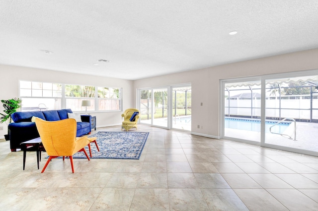 1904 6th Ave SE, Vero Beach, FL 32962 - living room featuring baseboards, tile patterned flooring, a textured ceiling, and visible vents