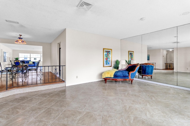 1904 6th Ave SE, Vero Beach, FL 32962 - sitting room featuring visible vents, tile patterned flooring, baseboards, and an upstairs landing