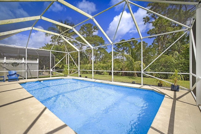 outdoor pool with glass enclosure and a patio area