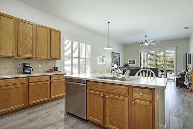 kitchen featuring stainless steel dishwasher, visible vents, a sink, and light wood-style flooring