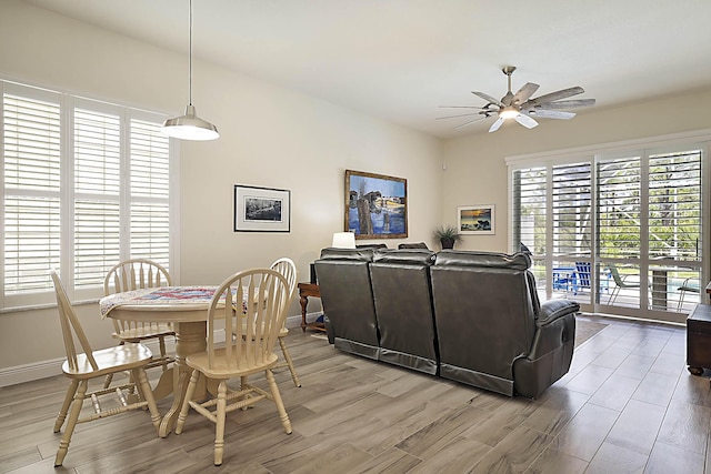 dining room featuring baseboards, ceiling fan, and light wood-style flooring