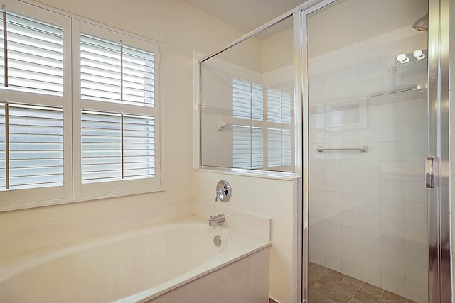 bathroom featuring a bath and a stall shower