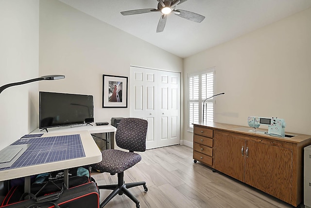 office space featuring baseboards, ceiling fan, light wood finished floors, and lofted ceiling