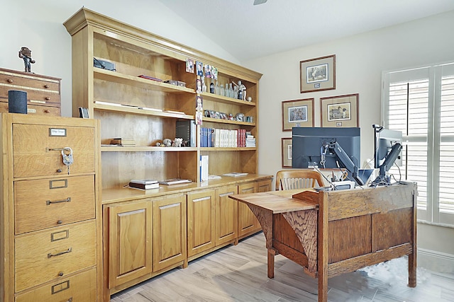 home office featuring lofted ceiling, light wood-style flooring, and a wealth of natural light