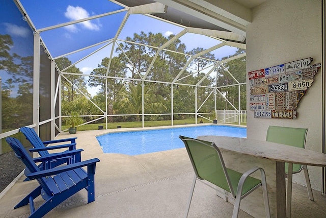 outdoor pool featuring glass enclosure and a patio area