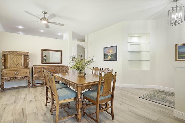 dining area with baseboards, recessed lighting, built in shelves, light wood-style flooring, and ceiling fan with notable chandelier