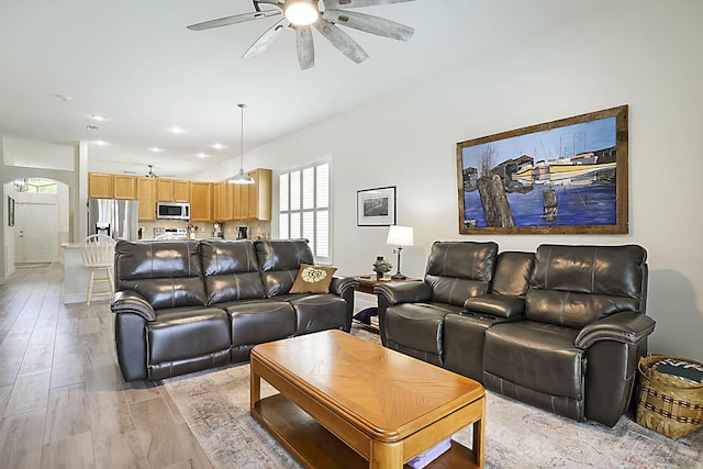 living room with recessed lighting, arched walkways, light wood-style flooring, and ceiling fan