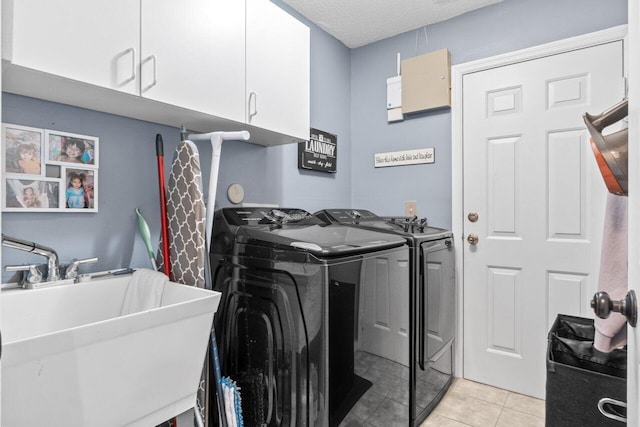 13029 Meadowbreeze Dr, Wellington, FL 33414 - washroom with washer and clothes dryer, a textured ceiling, a sink, light tile patterned floors, and cabinet space