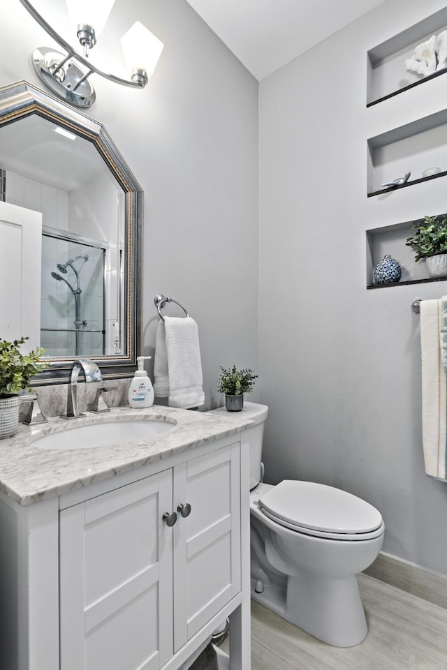 17744 Candlewood Ter, Boca Raton, FL 33487 - full bath with vanity, wood finished floors, toilet, baseboards, and a shower with shower door