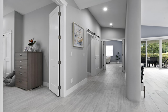 17744 Candlewood Ter, Boca Raton, FL 33487 - hallway with baseboards, a barn door, light wood finished floors, and a wealth of natural light