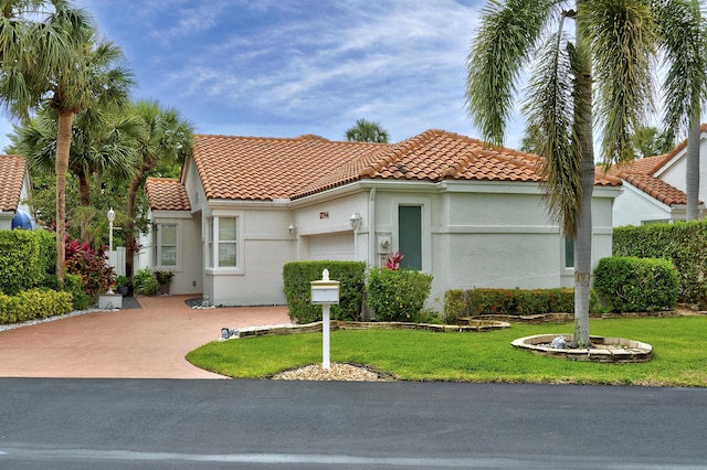 17744 Candlewood Ter, Boca Raton, FL 33487 - mediterranean / spanish-style home featuring a tiled roof, an attached garage, stucco siding, and a front lawn