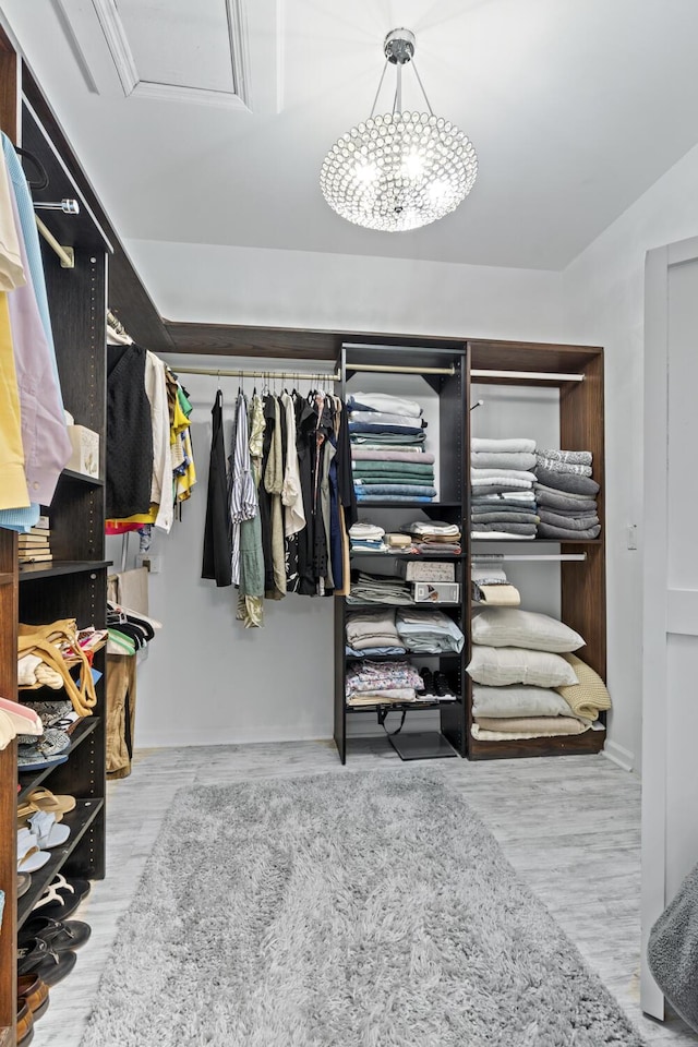 17744 Candlewood Ter, Boca Raton, FL 33487 - walk in closet featuring attic access, wood finished floors, and a chandelier