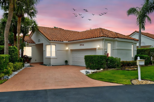 17744 Candlewood Ter, Boca Raton, FL 33487 - mediterranean / spanish house with a tiled roof, driveway, a yard, an attached garage, and stucco siding