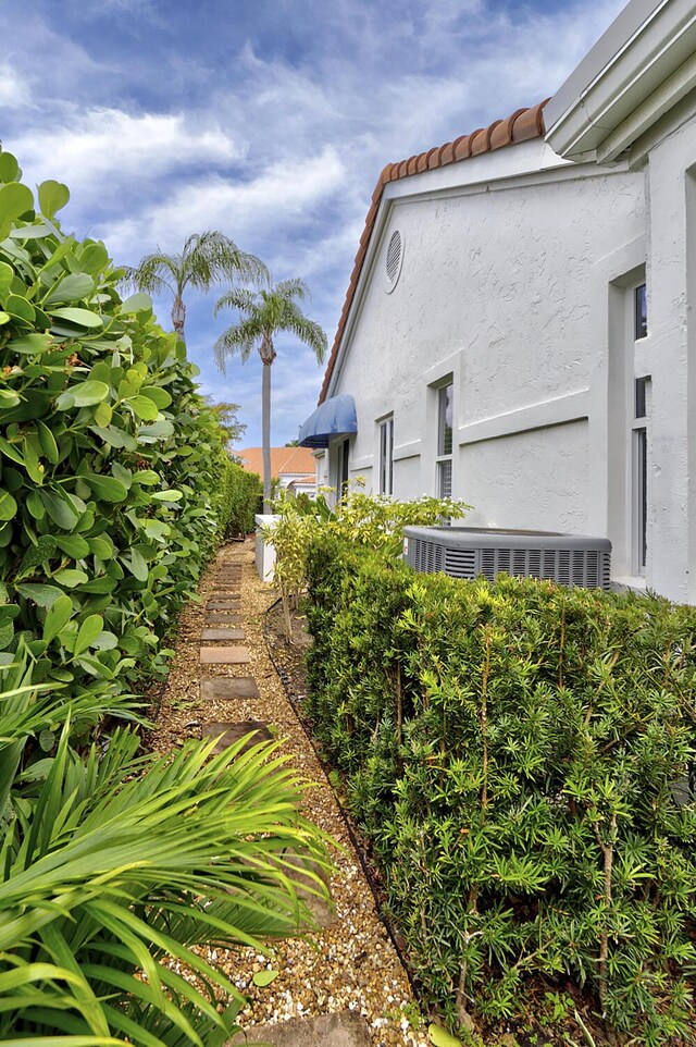 17744 Candlewood Ter, Boca Raton, FL 33487 - view of side of property with central air condition unit, stucco siding, and a tiled roof