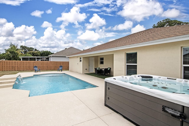 view of swimming pool featuring fence, a hot tub, a fenced in pool, and a patio area