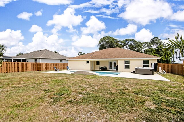 rear view of property featuring a patio, french doors, a fenced backyard, and a hot tub
