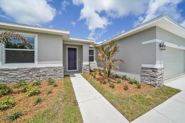 view of front of home featuring stucco siding, an attached garage, and stone siding