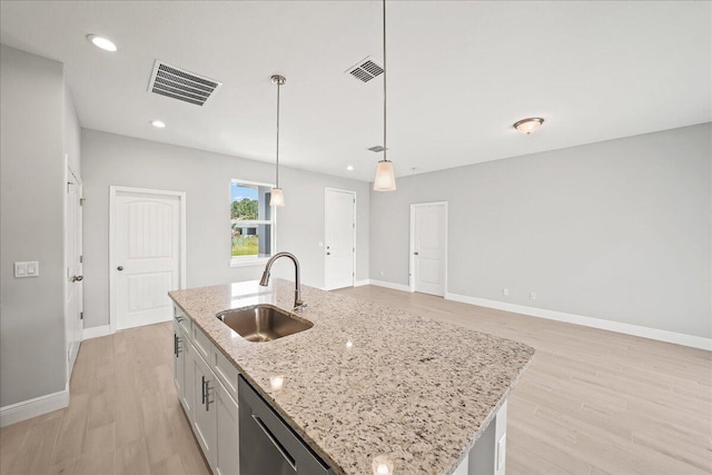 kitchen featuring stainless steel dishwasher, visible vents, a sink, and light wood-style floors