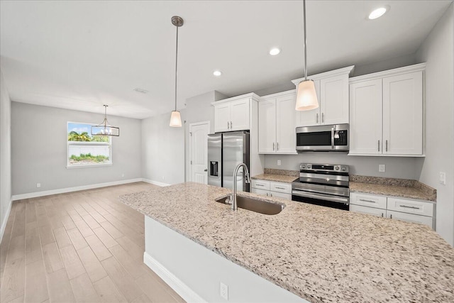 kitchen featuring a sink, stainless steel appliances, white cabinets, baseboards, and recessed lighting