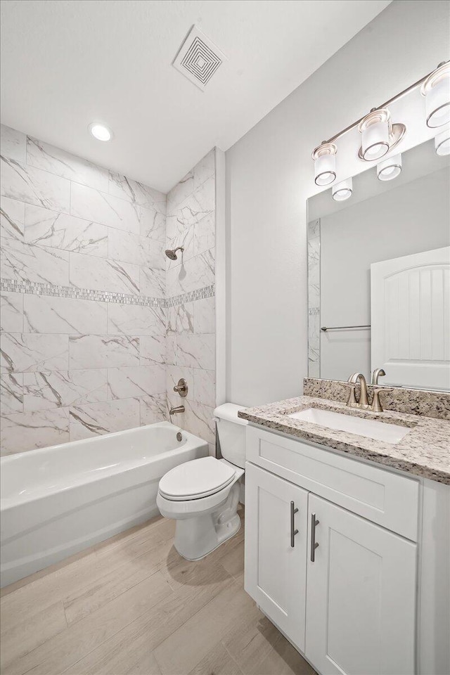 bathroom featuring bathtub / shower combination, visible vents, vanity, and toilet