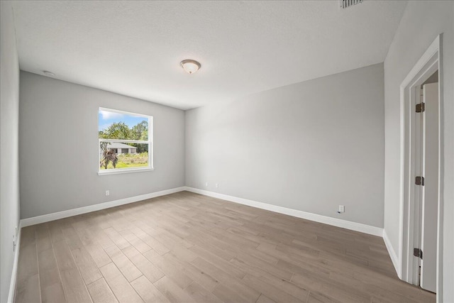 unfurnished room with baseboards and wood finished floors