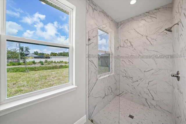 bathroom featuring a marble finish shower, a wealth of natural light, and recessed lighting