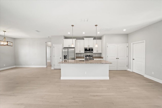 kitchen with light wood-type flooring, baseboards, a sink, and appliances with stainless steel finishes