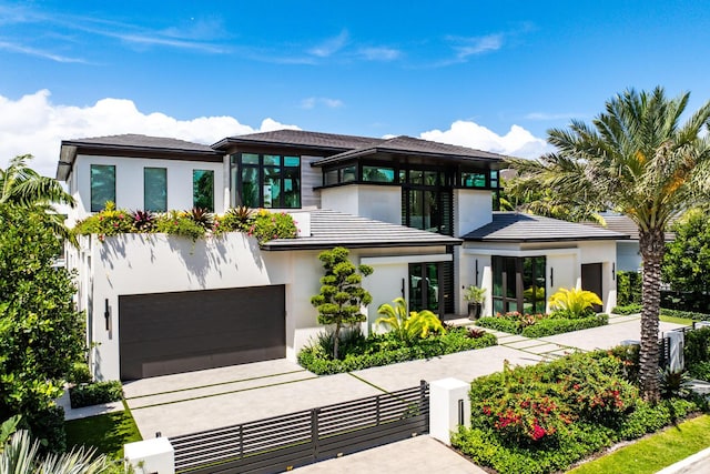 207 W Coconut Palm Rd, Boca Raton, FL 33432 - prairie-style house featuring a garage, a fenced front yard, a gate, driveway, and stucco siding