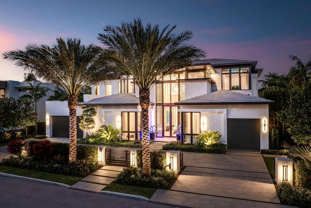 207 W Coconut Palm Rd, Boca Raton, FL 33432 - view of front of house featuring stucco siding, a fenced front yard, a gate, a garage, and driveway