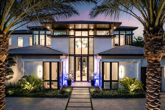 207 W Coconut Palm Rd, Boca Raton, FL 33432 - back of house at dusk with stucco siding and french doors