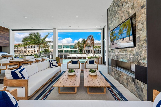 207 W Coconut Palm Rd, Boca Raton, FL 33432 - living room featuring a fireplace, expansive windows, and a healthy amount of sunlight