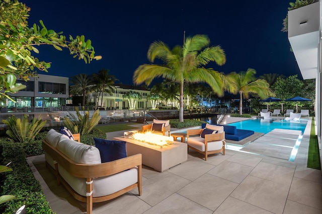 207 W Coconut Palm Rd, Boca Raton, FL 33432 - back of house at dusk with stairway, a balcony, a patio area, outdoor lounge area, and an outdoor pool