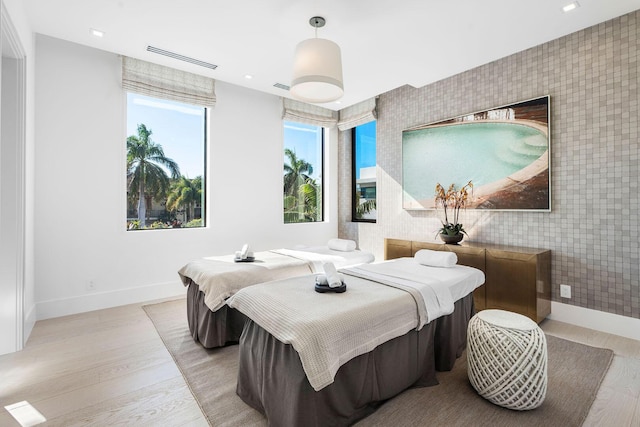 207 W Coconut Palm Rd, Boca Raton, FL 33432 - bedroom with light wood-type flooring, an accent wall, wallpapered walls, and baseboards