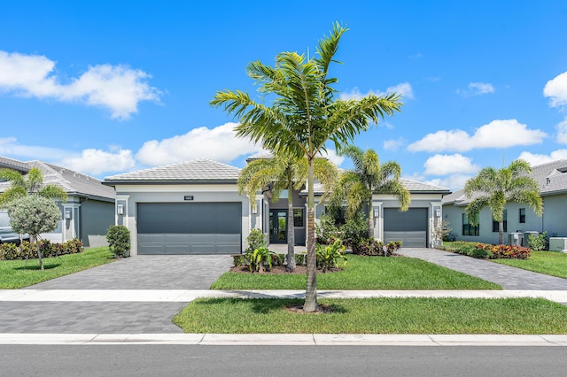 view of front of house featuring a front yard, an attached garage, and stucco siding