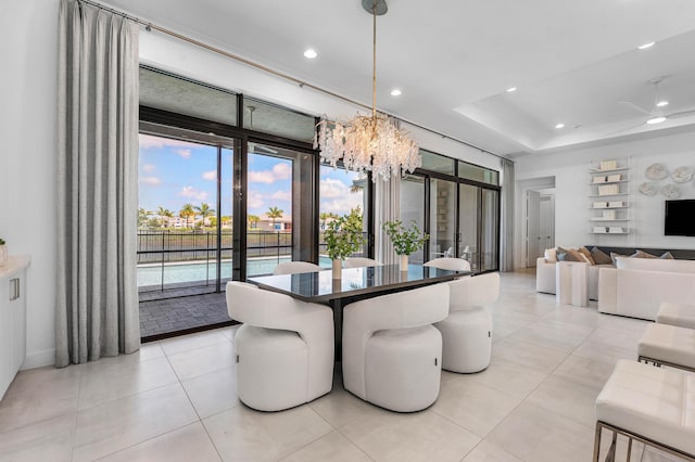 dining space with a chandelier, recessed lighting, light tile patterned flooring, baseboards, and a tray ceiling