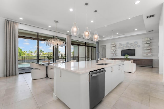 kitchen with dishwasher, a sink, a chandelier, white cabinetry, and a kitchen island with sink
