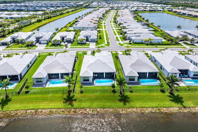aerial perspective of suburban area with a pool and a nearby body of water