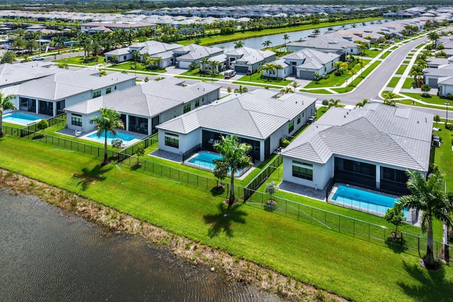 aerial view of residential area with a pool and a nearby body of water