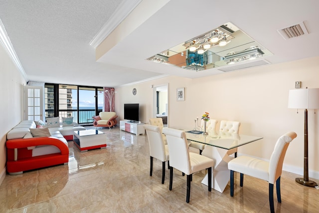 dining room with a textured ceiling, baseboards, visible vents, a wall of windows, and ornamental molding