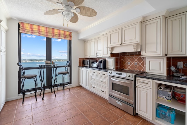 kitchen featuring dark countertops, a textured ceiling, backsplash, and appliances with stainless steel finishes
