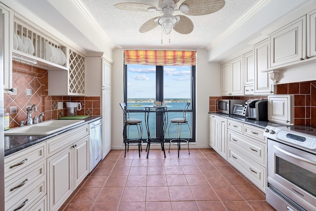 kitchen featuring a textured ceiling, appliances with stainless steel finishes, a ceiling fan, and a sink