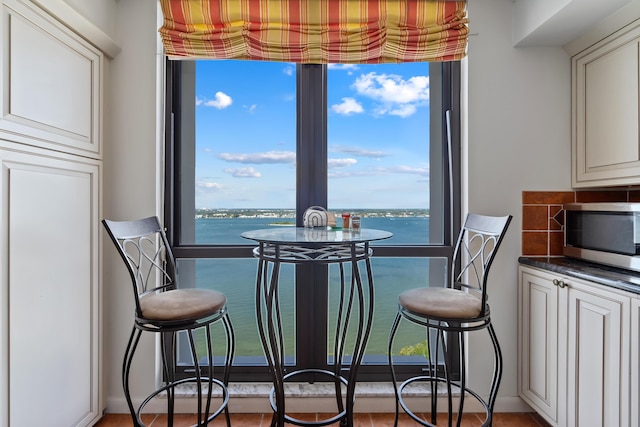dining area with a wealth of natural light and a water view