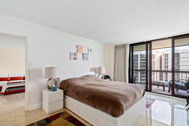 bedroom featuring crown molding, a textured ceiling, light tile patterned floors, a wall of windows, and access to outside