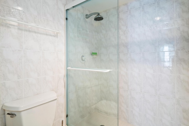 bathroom featuring a shower stall and toilet