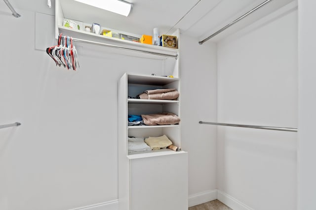 walk in closet with wood finished floors