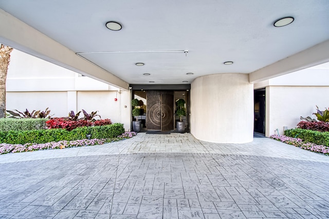 view of exterior entry featuring a patio area and stucco siding