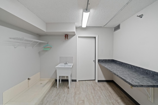 mudroom featuring visible vents, baseboards, wood finished floors, and a textured ceiling