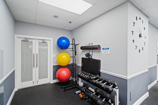 workout room with baseboards, visible vents, french doors, and a drop ceiling